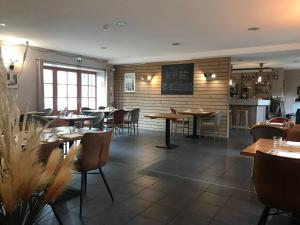a dining room with tables and chairs in a restaurant at L'Estampille in Saint-Vidal