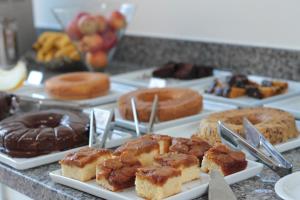 a bunch of different types of pastries on a counter at Revitalle Hotel in Votuporanga