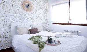 a bedroom with a white bed with a plant on it at El apartartamento de Santa Eva by Just Room in Miengo