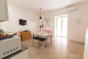 a kitchen and dining room with a table and chairs at LA PERLA in Cefalù +5 photos