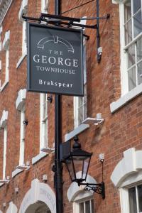 ein Schild an der Seite eines Backsteingebäudes in der Unterkunft The George Townhouse in Shipston on Stour