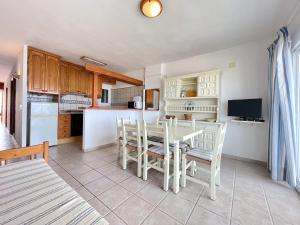 a kitchen and dining room with a table and chairs at Espardell nº4 in Es Pujols