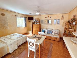 Una sala de estar con una cama, una mesa y sillas. en Eguzkilore, en Es Pujols