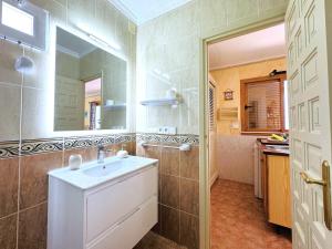 un baño con lavabo y espejo en Eguzkilore, en Es Pujols