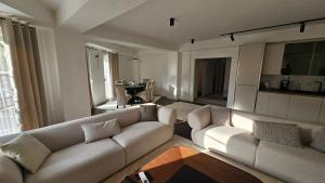 a living room with two white couches and a table at Apartment 5 in Gevgelija