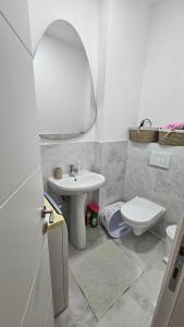 a bathroom with a sink and a toilet and a mirror at Apartment 5 in Gevgelija +3 photos
