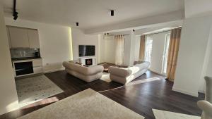 a living room with two couches and a kitchen at Apartment 5 in Gevgelija