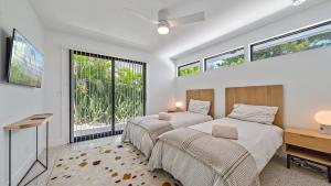 een slaapkamer met twee bedden, een bureau en ramen bij The Windward House in Siesta Key +49 foto's