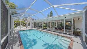 een binnenzwembad in een huis met een glazen plafond bij The Windward House in Siesta Key