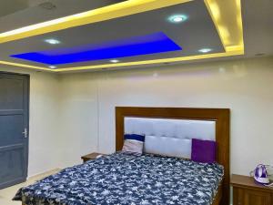 Un dormitorio con una cama con techo azul. en Charming and peaceful F3 House, en Dakar