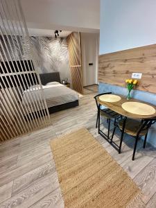ein Zimmer mit einem Tisch und einem Bett sowie einem Tisch und Stühlen in der Unterkunft Sofia Residence Studio Cetate in Târgu Neamţ + 25 Fotos