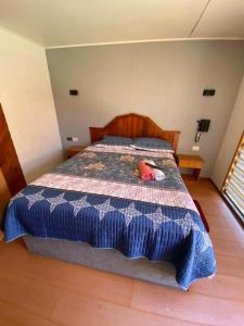 Un dormitorio con una cama con un animal de peluche encima. en Tierras del Sol, en Quilpué