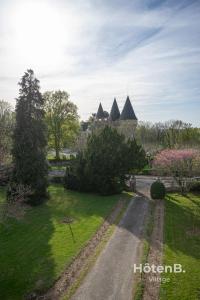 una strada che conduce a un edificio con tetti a punta di Maison Léonce Blanc - Prestige in Lubersac a Lubersac
