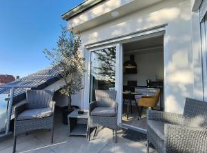 a patio with chairs and a table on a balcony at Modernes Apartment Melia in Hamm