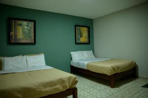 zwei Betten in einem Zimmer mit grünen Wänden in der Unterkunft A 90m de Feria, Céntrico y Acogedor - Departamento A220-1 in Aguascalientes