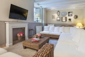 a living room with a white couch and a fireplace at Hotel-Balneari Sant Vicenç in El Pont de Bar