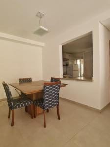ein Esszimmer mit einem Holztisch und Stühlen in der Unterkunft L23 apartamento alto padrão-Itagua in Ubatuba