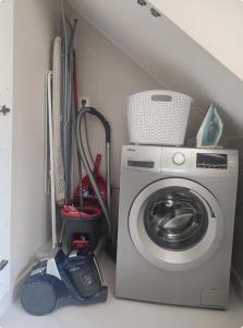 - une buanderie avec un lave-linge et un aspirateur dans l'établissement Charmante dépendance Arena La Défense, à Nanterre 2 autres photos