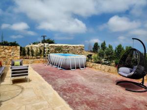 eine Terrasse mit Swimmingpool und zwei Stühlen in der Unterkunft Bmehrine The Inn in Byblos