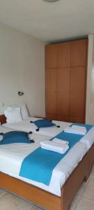 a bedroom with two beds with blue pillows at Rodica Studios in Kallithea Halkidikis