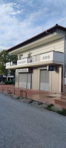 a white building with three windows on a street at Rodica Studios in Kallithea Halkidikis