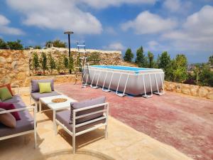 ein Pool im Garten mit Stühlen und einem Tisch in der Unterkunft Bmehrine The Inn in Byblos