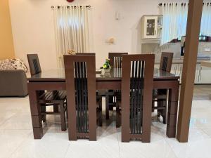 a dining room table with chairs and a kitchen at Water Pearl in Kosgama +12 photos
