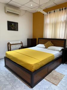 a bedroom with a large bed with a yellow blanket at Water Pearl in Kosgama