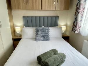 a bedroom with a white bed with a blue headboard at South Bay Hideaway, Brixham in Brixham