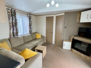 a living room with a couch and a television at South Bay Hideaway, Brixham in Brixham