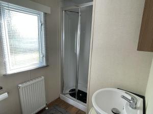 a bathroom with a shower and a sink at South Bay Hideaway, Brixham in Brixham +15 photos