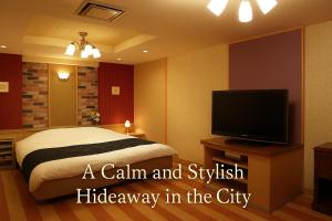 ein Schlafzimmer mit Bett und Flachbildfernseher in der Unterkunft The Study Room Ikutama in Osaka