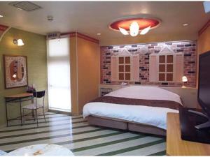 ein Schlafzimmer mit Bett, Schreibtisch und Fernseher in der Unterkunft The Study Room Ikutama in Osaka