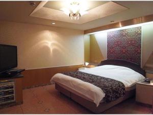 ein Schlafzimmer mit Bett und Flachbildfernseher in der Unterkunft The Study Room Ikutama in Osaka