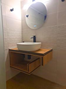 Un baño con un lavabo blanco y un espejo. en Rhódia & Sun by Booking Kottas, en Ixia 29 fotos más