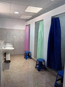 a bathroom with a sink and two blue stools at Auquis Hostel in Cusco +119 photos