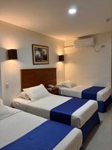 マチャラにあるHotel Puertoventuraのホテルルーム(青と白のシーツが備わるベッド2台付) +4枚の写真