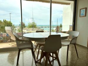 カレタ・デ・ベレスにあるEl Varadero By Solymar Holidayの大きな窓のある部屋にあるテーブルと椅子