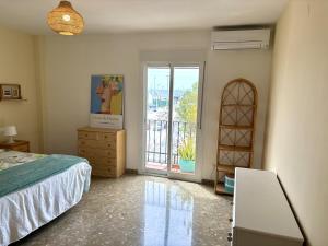 カレタ・デ・ベレスにあるEl Varadero By Solymar Holidayのベッドルーム1室(ベッド1台付)、バルコニーへのドアが備わります。