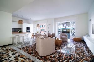 a living room with a couch and chairs and a kitchen at Casa Alyx by PortofinoHomes in Santa Margherita Ligure