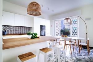 a kitchen with white cabinets and a table with stools at Casa Alyx by PortofinoHomes in Santa Margherita Ligure