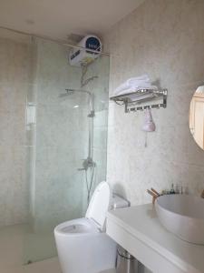 ein Badezimmer mit Dusche, Toilette und Waschbecken in der Unterkunft Rocosy Villa DaLat in Khu Chi Lăng