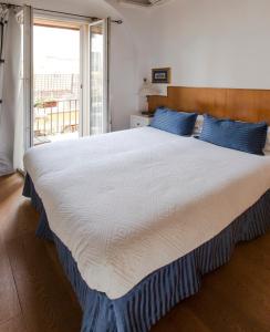 a bedroom with a large white bed with blue pillows at Pettinary Village B&B in Rome