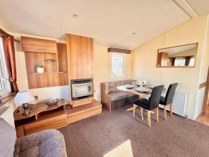 a living room with a dining table and a couch at Fully adapted caravan in Meliden