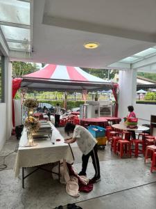 a person is working at a table in a restaurant at 142 spacious 3storey 6BR 6bath for big family wedding birthday easy parking in Gelugor