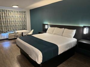 Una habitación de hotel con una cama, una mesa y una ventana. en Studio 6 Suites Gardena, CA, en Gardena