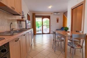 a kitchen with a counter and a table and chairs at Appartamento Pina Caletta sul mare con parcheggio privato in La Caletta