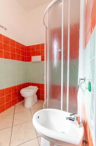 une salle de bain avec toilettes, lavabo et douche dans l'établissement Appartamento Pina Caletta sul mare, à La Caletta