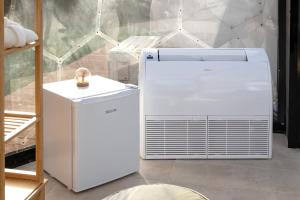 a white refrigerator in a room next to a table at Folià Natural Experience in San Vito dei Normanni