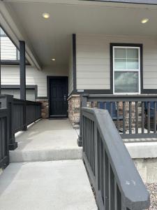 a front porch of a house with a black door at Guest Suite in Castle Rock in Castle Rock